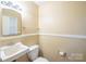 Powder room with pedestal sink, toilet and vanity mirror at 1332 Midwood Dr, Gastonia, NC 28052
