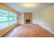 Bright living room with hardwood floors, a brick fireplace and built-in shelves, and large windows at 1332 Midwood Dr, Gastonia, NC 28052