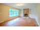 Cozy living room showcasing hardwood floors, a brick fireplace with built-in shelves and ample natural light at 1332 Midwood Dr, Gastonia, NC 28052