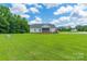Expansive backyard with a well-maintained lawn, mature trees, and a view of the home's exterior at 1347 Norman Dr, Rock Hill, SC 29732