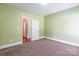 Empty bedroom featuring neutral walls, carpet flooring, and a connecting door at 1347 Norman Dr, Rock Hill, SC 29732