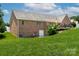 View of brick home with well-maintained lawn, deck, and access door at 139 Hardwick Dr, Mooresville, NC 28115