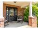 Inviting front porch with rocking chairs, black door, and brick pillars at 139 Hardwick Dr, Mooresville, NC 28115