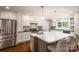 Modern kitchen features stainless steel appliances, an island with bar stool seating, and white cabinets at 139 Hardwick Dr, Mooresville, NC 28115