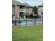 Community pool surrounded by lush lawn, black fence, and patio furniture at 140 Lake Concord Ne Rd, Concord, NC 28025