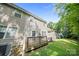 Backyard view of a townhome with a wood deck, lush green grass, and mature trees at 14664 Lions Paw St, Charlotte, NC 28273