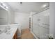 Neutral bathroom with glass shower doors, ample lighting and a built-in shelving unit at 14664 Lions Paw St, Charlotte, NC 28273