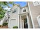 Low angle of a tan townhouse with a single car garage and black front door at 14664 Lions Paw St, Charlotte, NC 28273