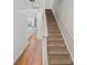 Hallway with hardwood floors, and a carpeted staircase with white walls at 14664 Lions Paw St, Charlotte, NC 28273