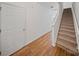 Hallway with hardwood floors and a white door on the left and carpeted staircase on the right at 14664 Lions Paw St, Charlotte, NC 28273