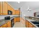 A kitchen featuring wood cabinets, black appliances, and a view into a sunlit living room at 14664 Lions Paw St, Charlotte, NC 28273