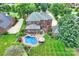 Aerial view of an estate with a pool, brick patio, well-manicured lawn, and mature trees at 159 Carsons Pl, Mooresville, NC 28117