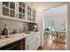 Chic bar area with white cabinetry, marble countertops, and a wine fridge, with a view to another room at 159 Carsons Pl, Mooresville, NC 28117