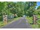 Long driveway leading to a gated entrance, flanked by stone pillars and lush landscaping at 159 Carsons Pl, Mooresville, NC 28117