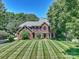 Beautiful brick two-story home with mature trees and a meticulously maintained lawn at 159 Carsons Pl, Mooresville, NC 28117