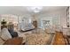 Inviting living room featuring hardwood floors, ample seating, and views into the bright kitchen and sunroom at 159 Carsons Pl, Mooresville, NC 28117