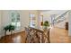 Well-lit office space with a glass-top desk, hardwood floors, and views to the front yard and staircase at 159 Carsons Pl, Mooresville, NC 28117