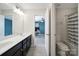 Bright bathroom featuring a double sink vanity and a shower with a blue and white striped shower curtain at 1604 Trentwood Dr, Fort Mill, SC 29715