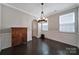 Spacious dining room featuring dark hardwood floors, wainscoting, and a modern chandelier at 1604 Trentwood Dr, Fort Mill, SC 29715