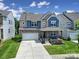 Inviting two-story home with stone accents, blue siding, well-maintained lawn and a cozy front porch at 1604 Trentwood Dr, Fort Mill, SC 29715