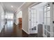 Elegant hallway features dark hardwood floors, arched doorways, and access to a bright office with glass doors at 1604 Trentwood Dr, Fort Mill, SC 29715