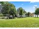 Expansive backyard featuring lush green grass, mature trees, charming bench, and a covered carport for parking at 1627 33Rd Ne Ave, Hickory, NC 28601