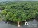 An aerial shot of a dock, lush trees, and a lake create a picturesque waterfront scene at 165 Futrell Lndg, New London, NC 28127
