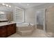 Bathroom showcasing a soaking tub, glass block window, and dark wood cabinets at 165 Futrell Lndg, New London, NC 28127