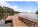 Exterior view of a brown wooden dock extending into a beautiful lake with trees in the background at 165 Futrell Lndg, New London, NC 28127