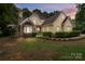 Charming stucco home featuring a stone facade, manicured landscaping, and inviting curb appeal at 165 Futrell Lndg, New London, NC 28127
