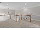 Spacious loft with neutral carpet, white railing, and a decorative chandelier at 165 Futrell Lndg, New London, NC 28127