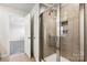 Bathroom with a glass-enclosed shower, neutral tiling, and access to bedroom at 2125 Rolling Hills Ct, Stanley, NC 28164