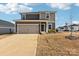 Two-story home with a tan two-car garage, brown siding, and a well-manicured lawn at 2125 Rolling Hills Ct, Stanley, NC 28164