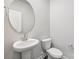 Powder room with a pedestal sink, round mirror, and standard white toilet at 2125 Rolling Hills Ct, Stanley, NC 28164