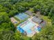 Aerial view showcasing community amenities: pool, tennis courts, and playground surrounded by lush trees at 2332 Hemby Pl, Charlotte, NC 28270