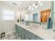 Bright bathroom featuring a double sink vanity with modern fixtures and decorative patterned tile flooring at 2332 Hemby Pl, Charlotte, NC 28270