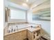 A tiled bathtub area features a built-in shelf, towels, and a privacy window with natural light at 2332 Hemby Pl, Charlotte, NC 28270