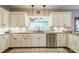 Bright kitchen featuring granite counters, white cabinets, a window, stainless appliances and a tile backsplash at 2332 Hemby Pl, Charlotte, NC 28270