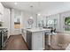 Open concept kitchen with island, stainless appliances, barstool seating and view to dining and outdoors at 2600 Mason Cir # A, Charlotte, NC 28205