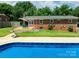 A backyard with a brick house, inground pool, and wooden deck for outdoor relaxation at 306 2Nd Avenue Ne Pl, Conover, NC 28613