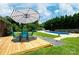 Outdoor deck with an umbrella and chairs, overlooking a sparkling blue pool at 306 2Nd Avenue Ne Pl, Conover, NC 28613