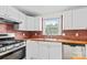 Well-lit kitchen featuring white cabinets, butcher block countertops, and stainless steel appliances at 306 2Nd Avenue Ne Pl, Conover, NC 28613