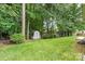 A large yard features green lawn and a small shed against a wooded backdrop at 3114 Pine Pointe St, Matthews, NC 28104
