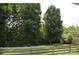 Lush backyard featuring mature trees and a charming wooden fence at 3136 Blueberry Dr, Monroe, NC 28110