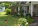 The front of the home features unique garden ornaments, a lush lawn, and tasteful landscaping at 3136 Blueberry Dr, Monroe, NC 28110