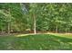 Picturesque backyard with a lush lawn and dense trees, offering privacy and a natural setting at 3284 Millstone Creek Rd, Lancaster, SC 29720