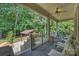 Relaxing covered porch with a ceiling fan, stylish furniture, and scenic backyard views at 3284 Millstone Creek Rd, Lancaster, SC 29720