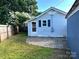 Backyard with a stone patio, a garage, wooden fence, and mature landscaping at 339 Mayflower Ave, Cramerton, NC 28032