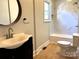 Bright bathroom featuring a vanity, toilet, and tub with marble tiling at 339 Mayflower Ave, Cramerton, NC 28032