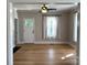 Light-filled living room with hardwood floors, large windows, and a classic ceiling fan at 339 Mayflower Ave, Cramerton, NC 28032